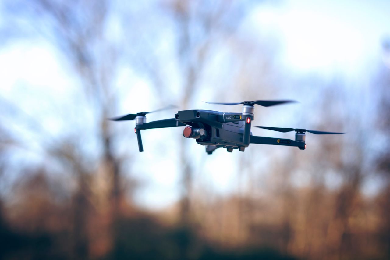 A sleek drone floats effortlessly against a daytime sky. Perfect for aerial photography enthusiasts.